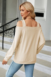 Cream textured open shoulder blouse with square neckline and long sleeves.