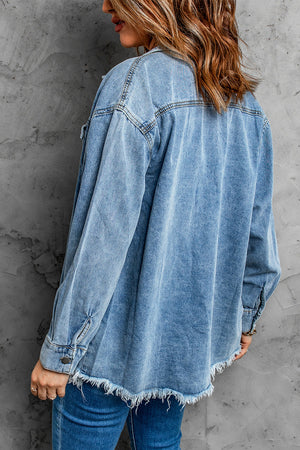 Oversized denim shirt jacket in dark blue with frayed hem and button cuffs.