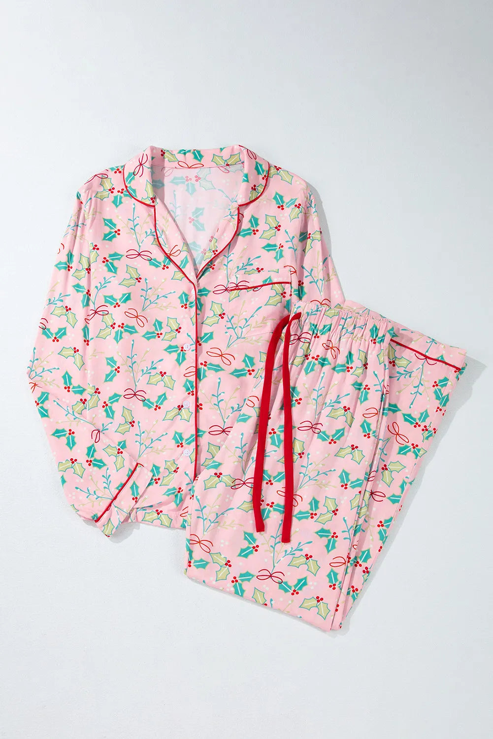 Blush pink pajama set with holly print, red piping, and red drawstring.