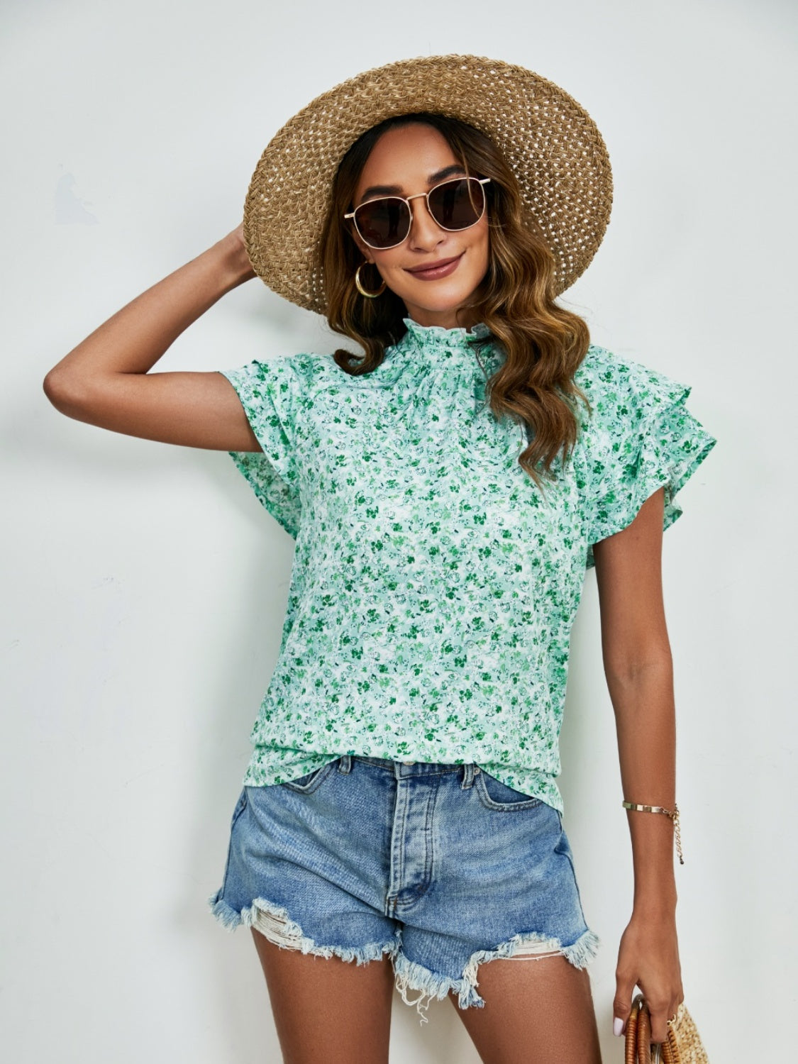 Light green floral blouse with ruffled neckline and flutter sleeves.
