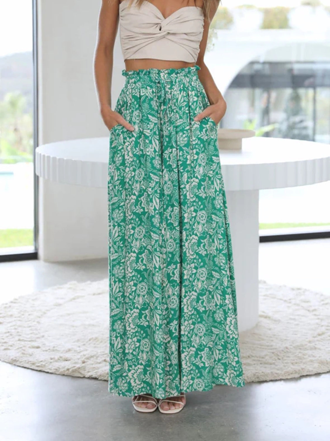 Sage green palazzo trousers with a white floral print and ruffled waist.