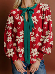 Red floral print blouse with green bow tie detail and smocked cuffs