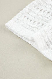 White open-knit acrylic cardigan with dolman sleeves and a textured pattern.