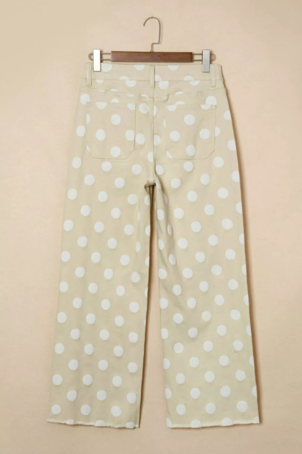 Polka dot high-waisted wide-leg jeans in beige denim with white dots and raw hem.