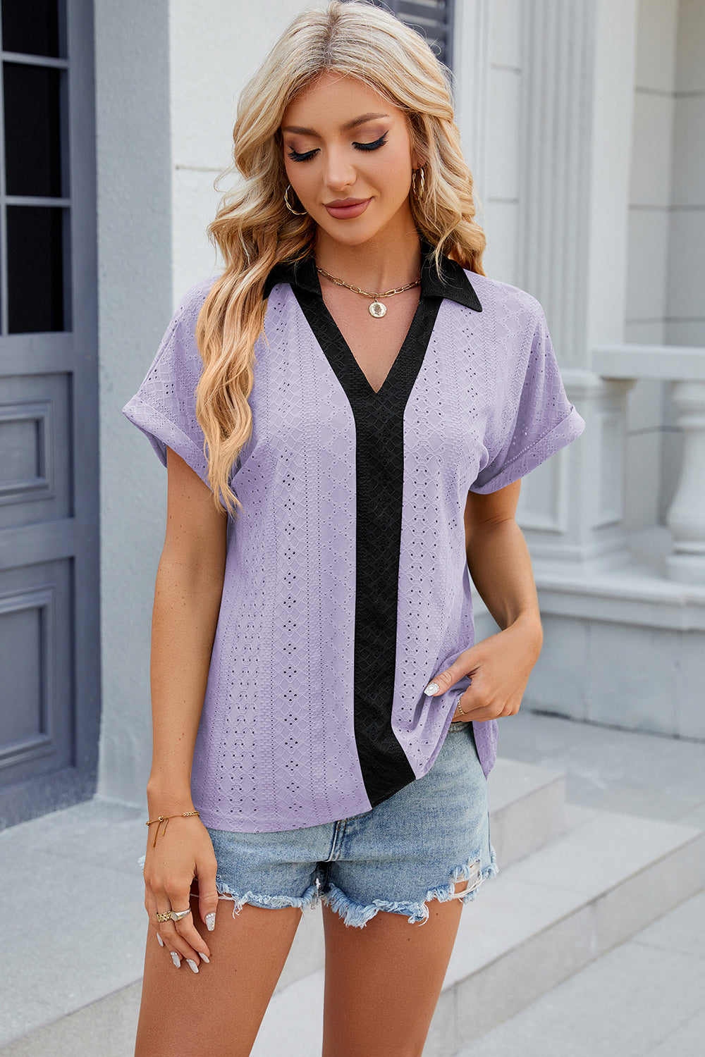 Lavender perforated polo top with black trim and short sleeves.