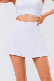 White performance pleated skort with a comfortable waistband and subtle pocket detail.
