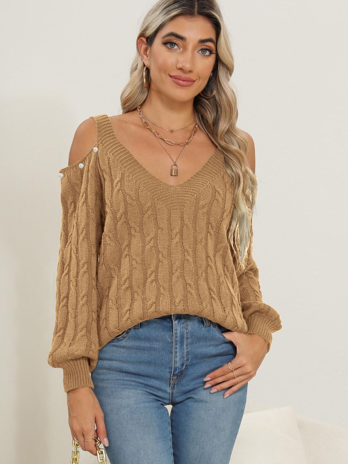 Camel cable knit cold shoulder sweater with button detail and V-neck.