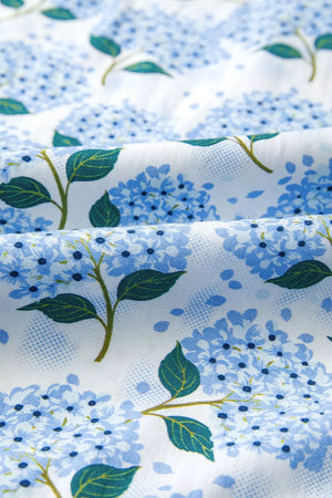 Midi dress with blue hydrangea print on white cotton blend fabric.
