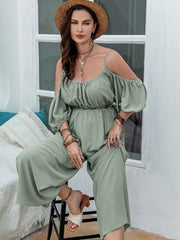 Sage off-shoulder jumpsuit with gathered waist, puff sleeves, and wide legs.