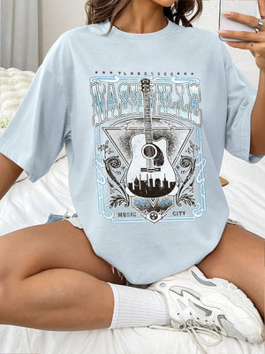 Light blue oversized graphic tee with Nashville Music City guitar and skyline print