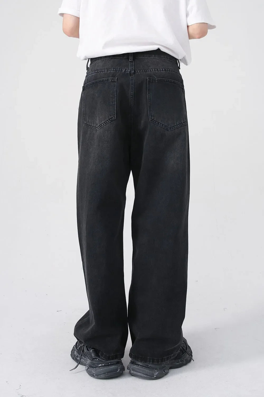 Black denim jeans with a relaxed fit and two back pockets.