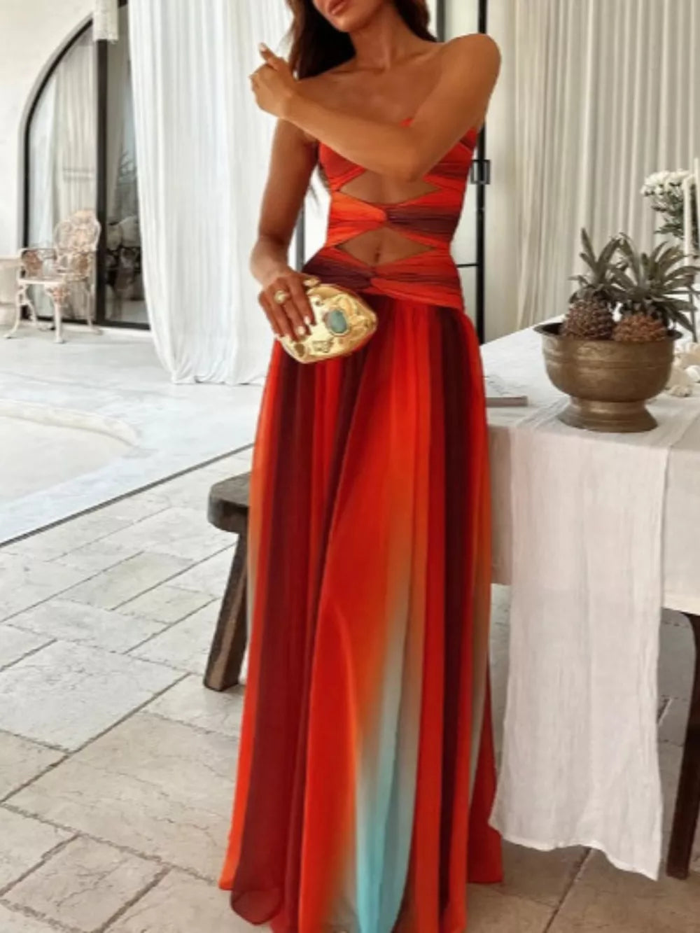 Maxi dress with ombre stripes, strapless neckline, and twisted bodice cutouts.