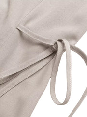 Midi dress in light beige with adjustable side ties and button detail.