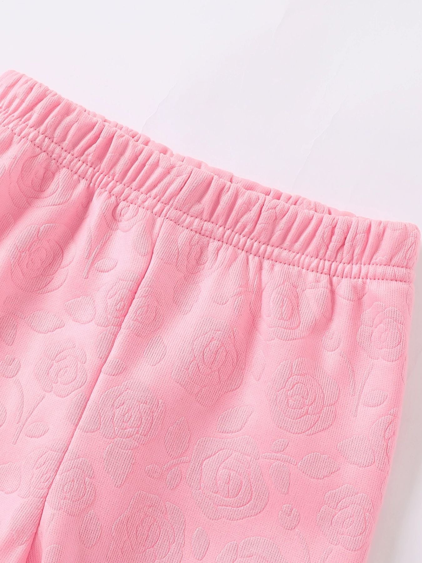Pink baby leggings with embossed floral pattern and elastic waistband