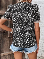 Black floral print blouse with lace trim short sleeves and V-neck.