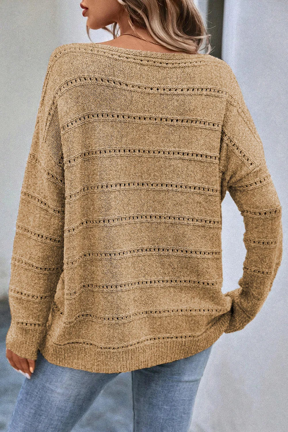 Tan openwork knit pullover sweater with boat neckline and long sleeves.