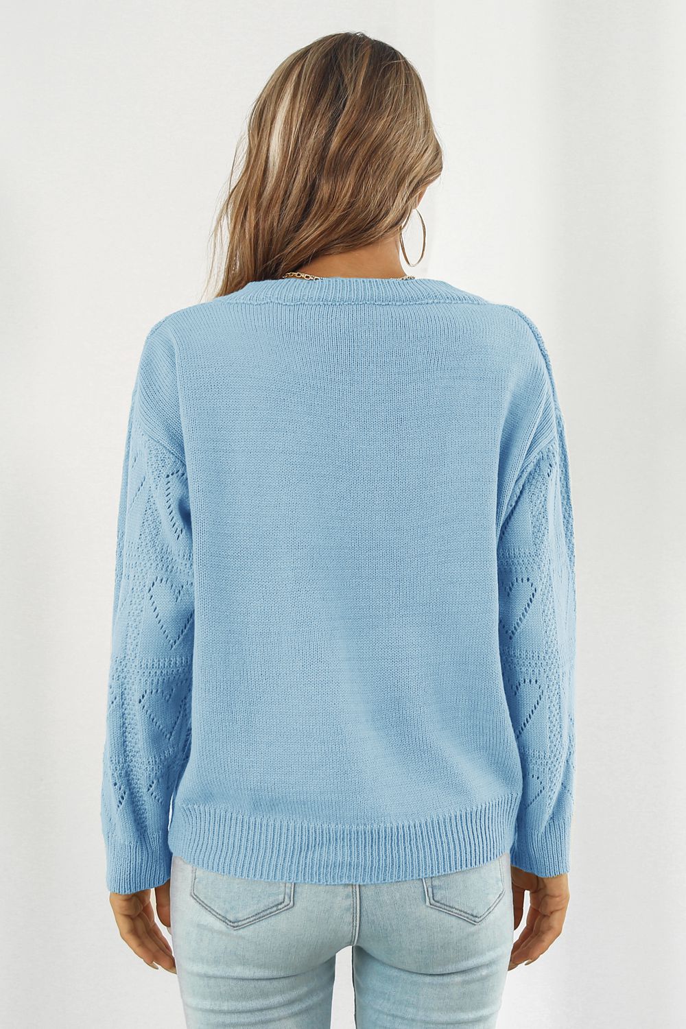 Light blue acrylic V-neck knit pullover sweater with heart stitch detail on sleeves.