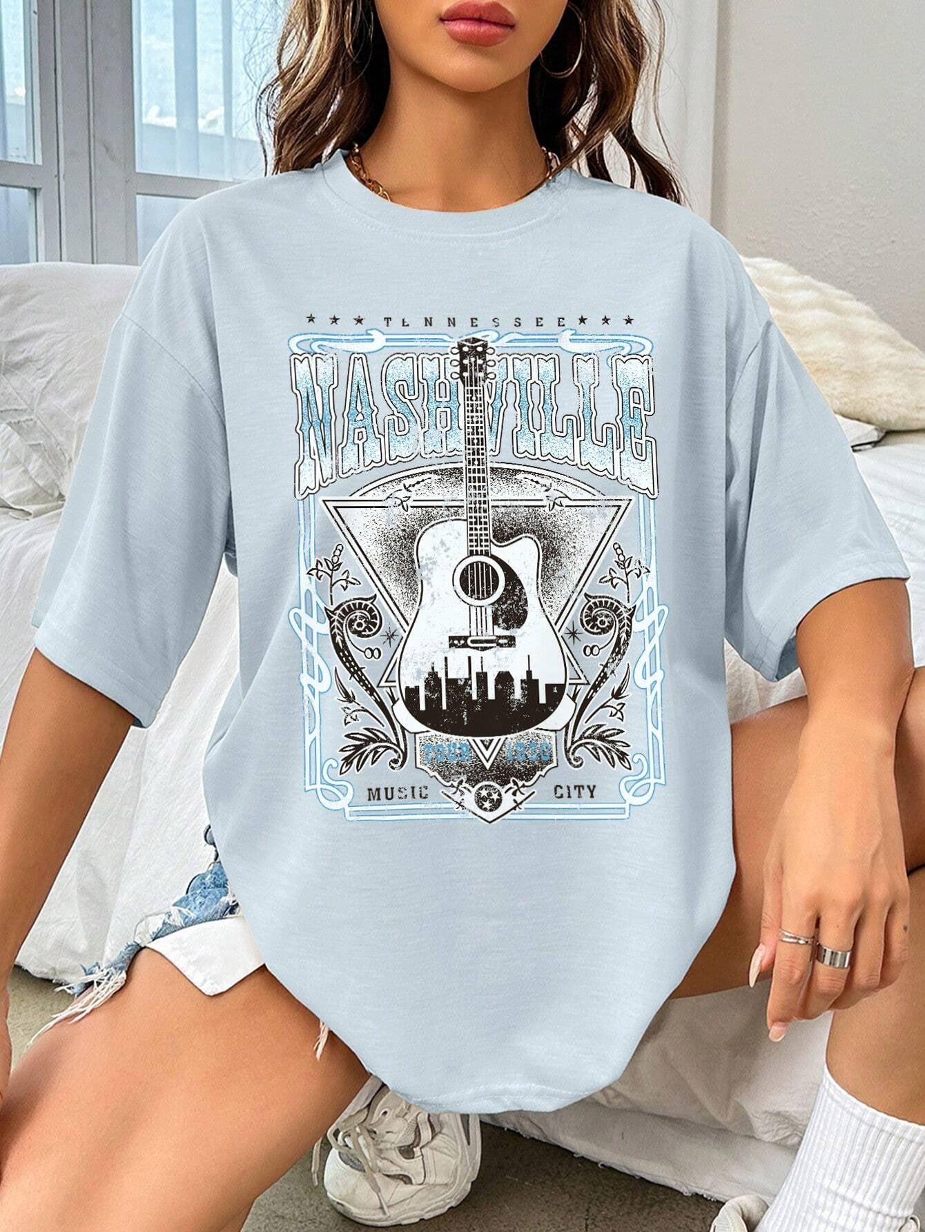 Light blue oversized graphic tee with Nashville Music City guitar and skyline print