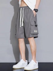 Grey cargo shorts with drawstring waist and multiple pockets, styled casually.