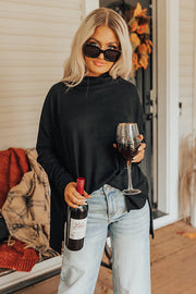 Black drape-front cowl neck tunic with long sleeves, styled casually with jeans.