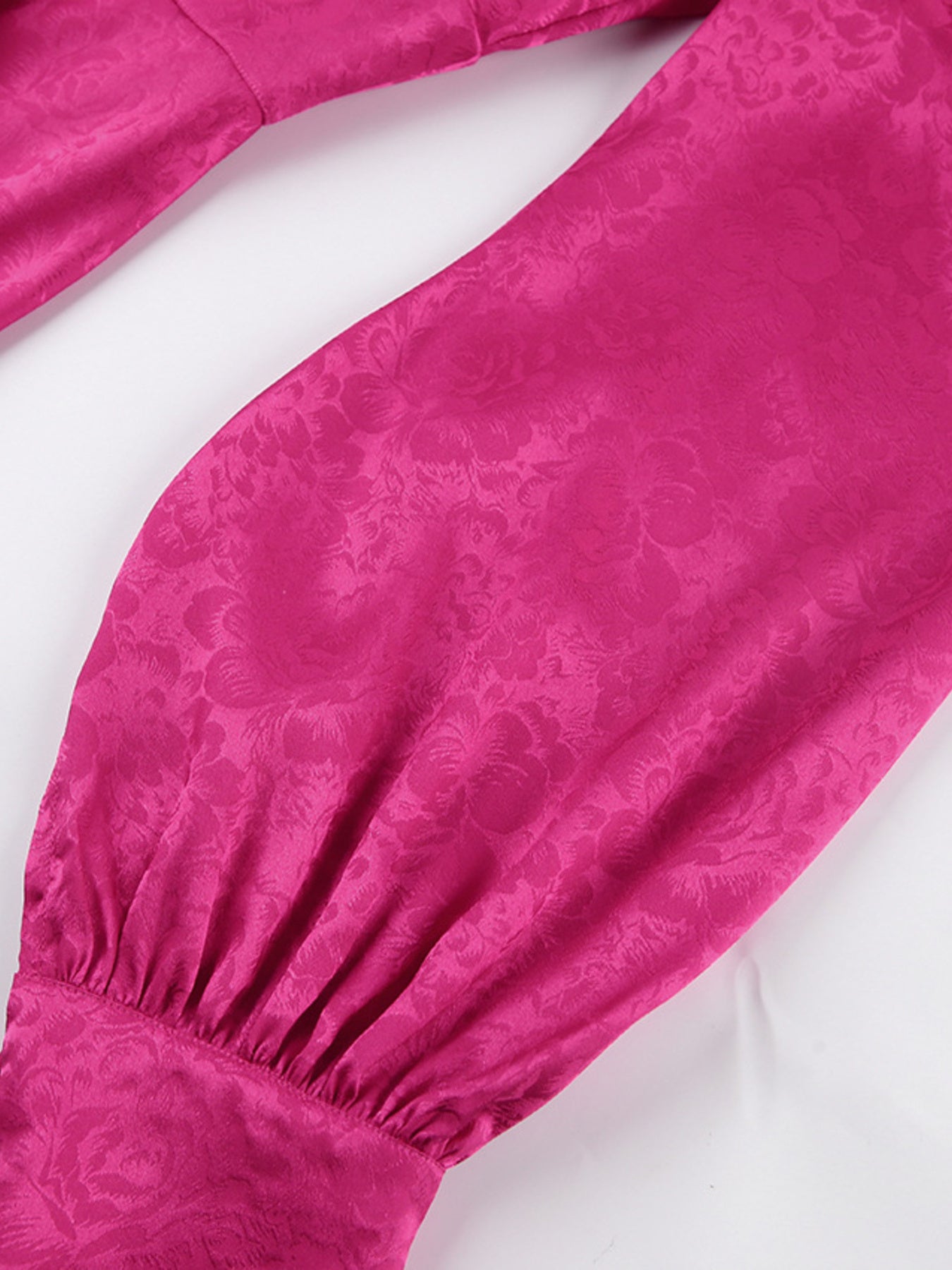 Vibrant cerise mini dress with embossed floral pattern, deep V-neck, and lantern sleeves.