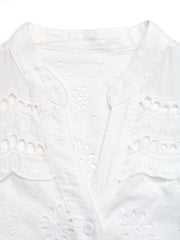 White eyelet embroidered button-up maternity shirt with V-neck and cutouts.