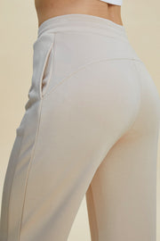 Beige sculpted joggers with drawstring waist and side pocket detail.