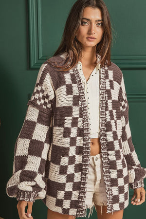 Chic checkered acrylic cardigan with balloon sleeves and open front, styled with a white top and shorts.