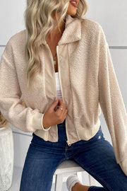 Cream teddy fleece bomber jacket with collared neck and zip front, styled with jeans.