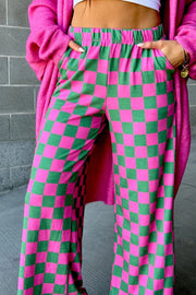 Checkerboard palazzo trousers in pink and green with elastic waist and wide leg.