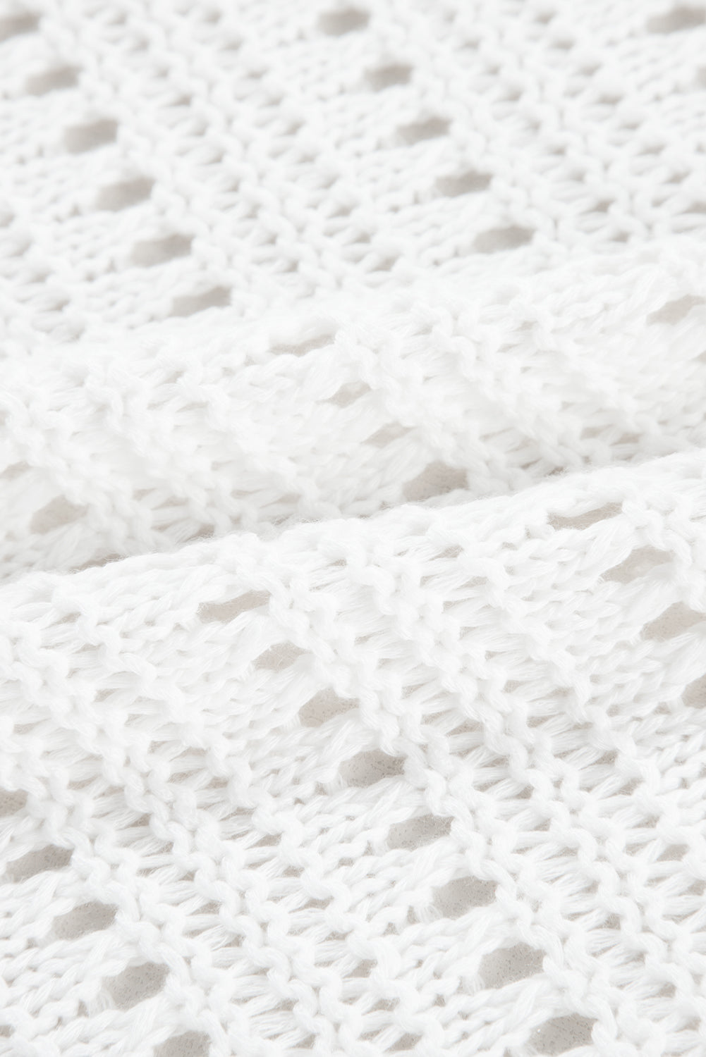 White open-knit dolman sleeve cardigan with a textured acrylic weave.