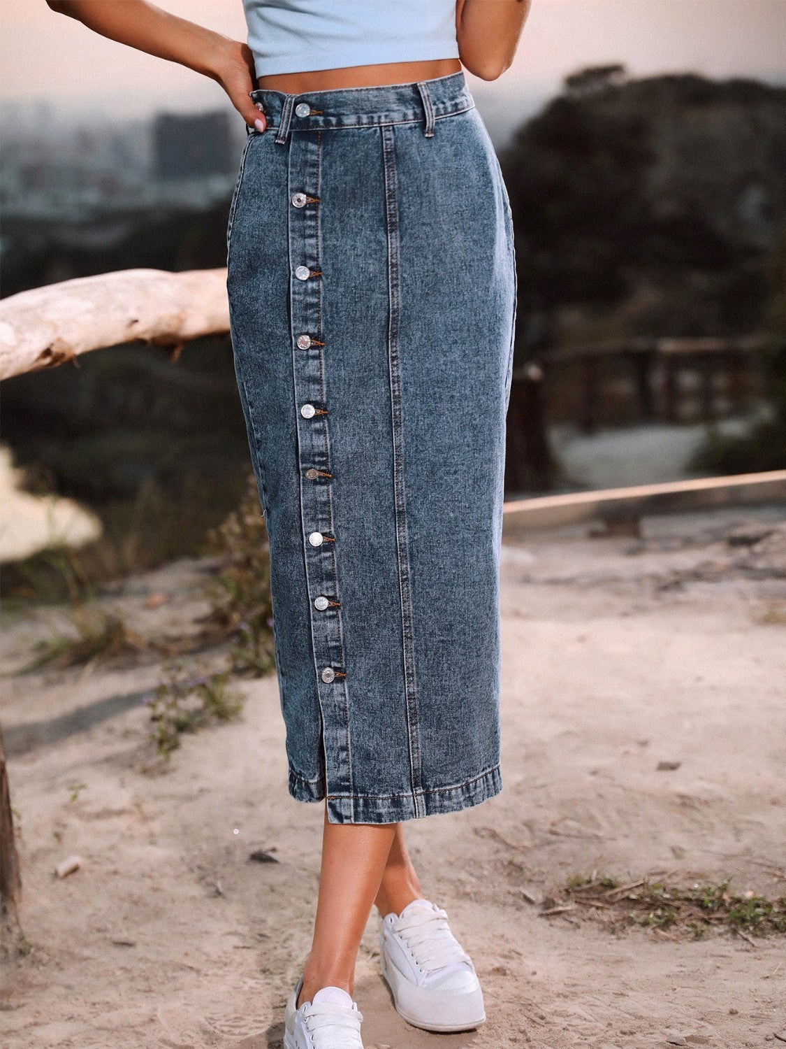Button-front denim midi skirt in a medium blue wash with a slit hem.