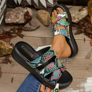 Distinctive two-strap platform sandals with a colorful snakeskin pattern and black sole.