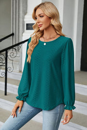 Textured puff sleeve blouse in deep teal with ruffle cuffs and a round neckline.
