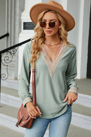 Light green textured V-neck blouse with lace trim on neckline and cuffs.