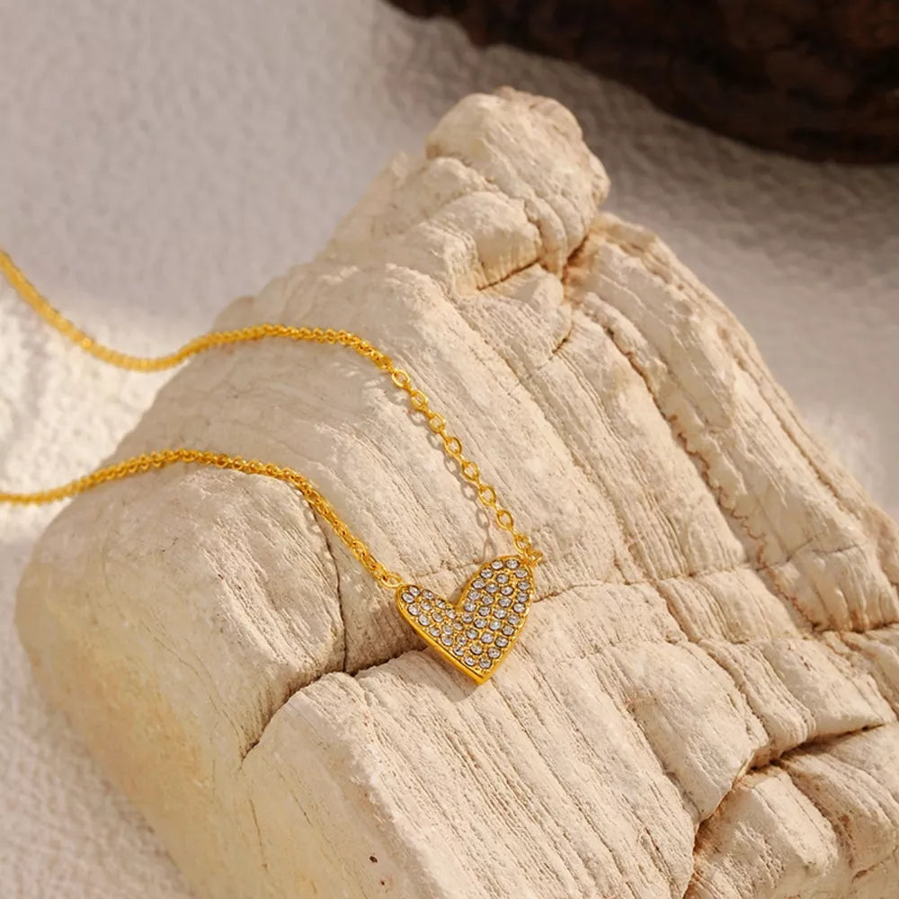 Gold necklace with a rhinestone heart pendant.