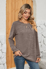 Mocha knit top with pleated yoke and ruffled cuffs, long sleeves.