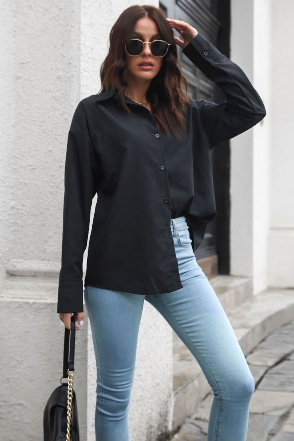 Black oversized cotton poplin shirt with button front and long sleeves.