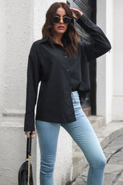 Black oversized cotton poplin shirt with button front and long sleeves.