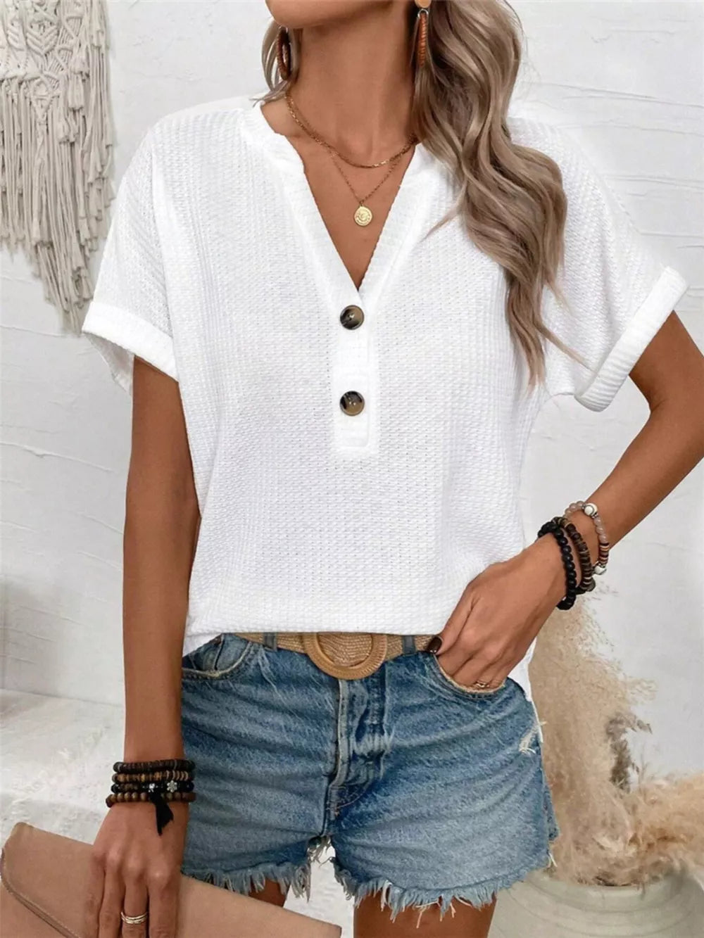 White waffle knit V-neck t-shirt with button detail and cuffed sleeves.