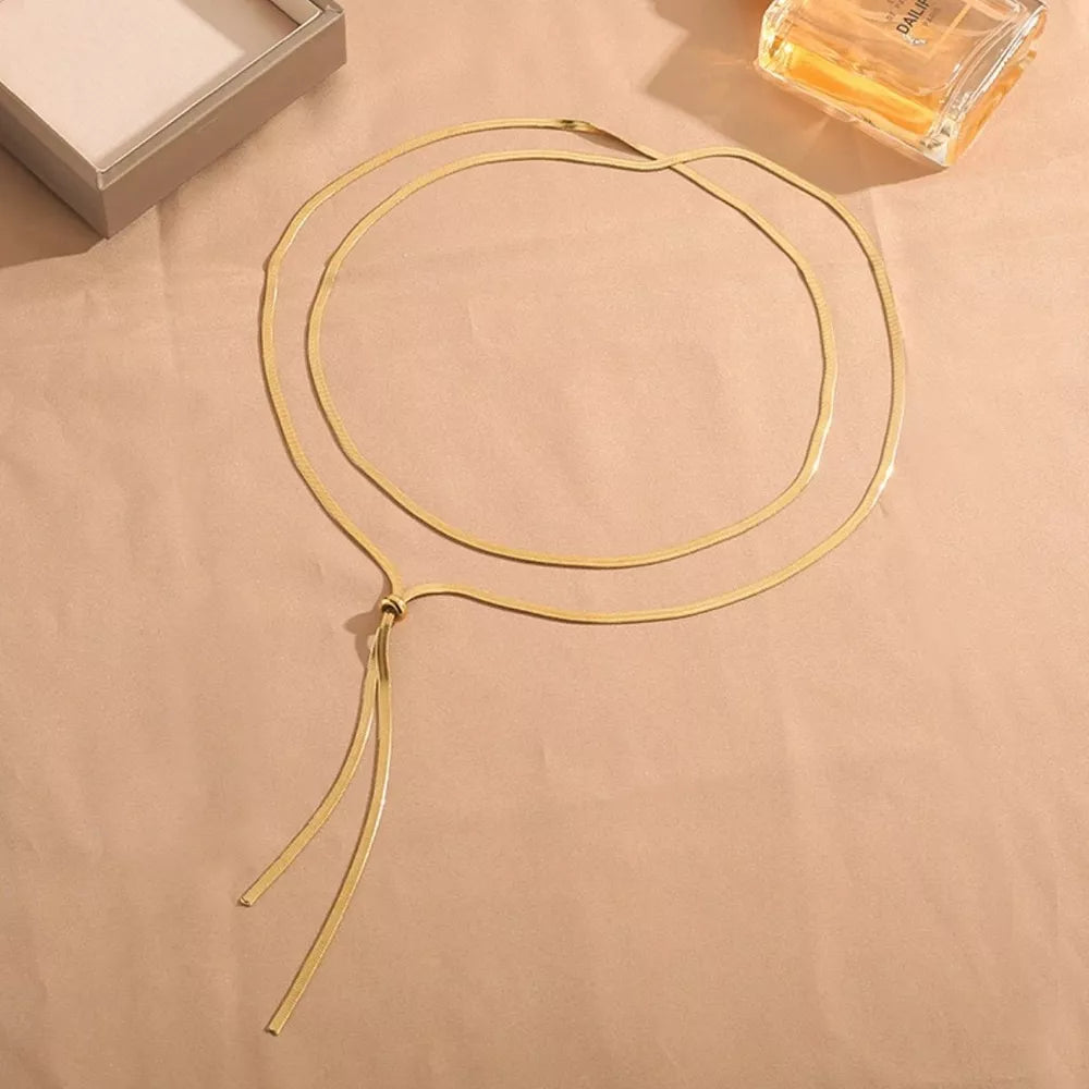 Gold layered snake chain necklace with a knot and dangling ends.