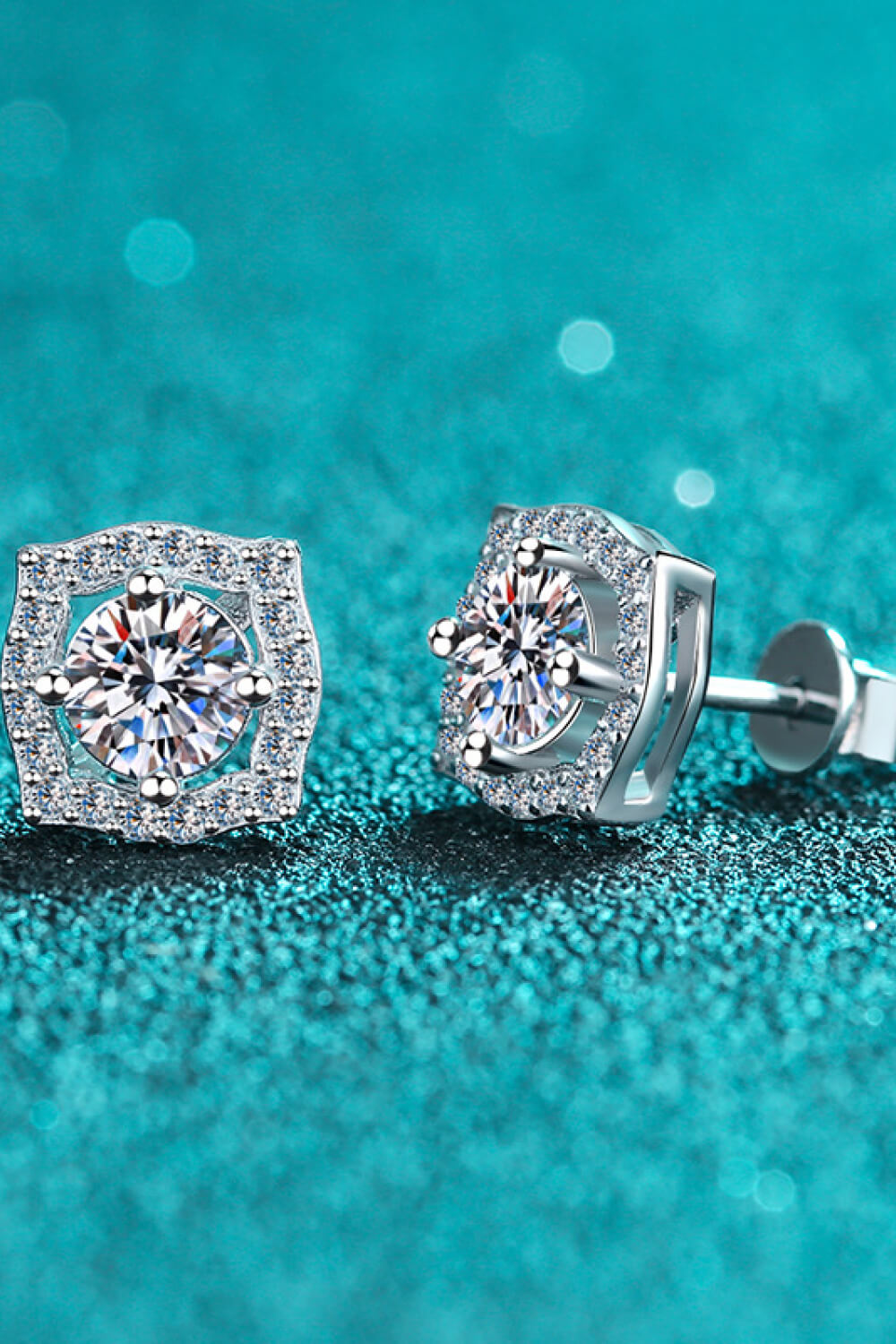 Scalloped halo moissanite stud earrings in silver with a central round cut stone surrounded by smaller stones.