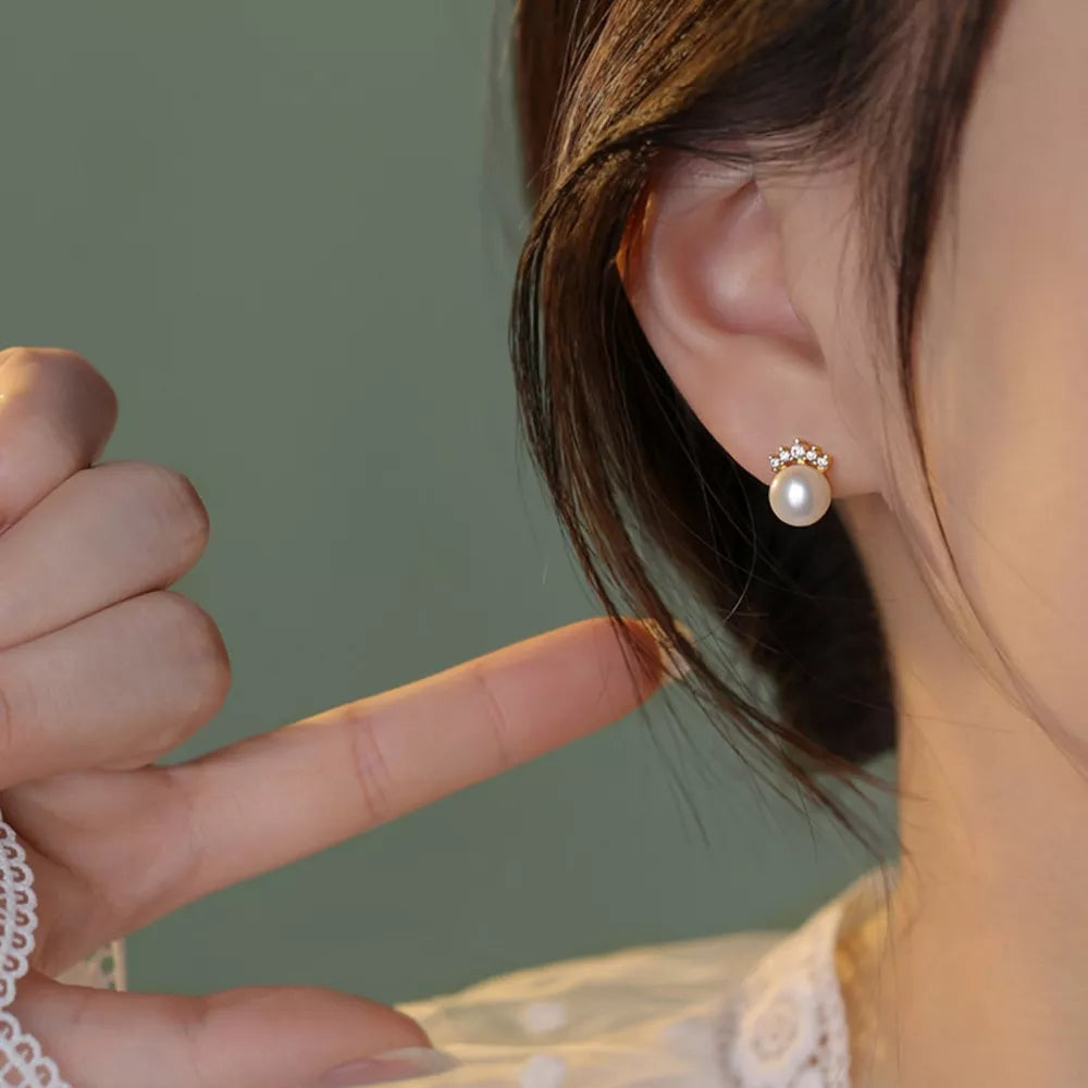 Pearl and zircon stud earrings with delicate gold setting.