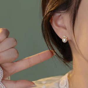 Pearl and zircon stud earrings with delicate gold setting.