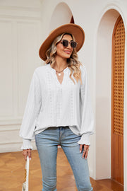 White eyelet detail blouse with V-neck and poet sleeves, cinched cuffs.