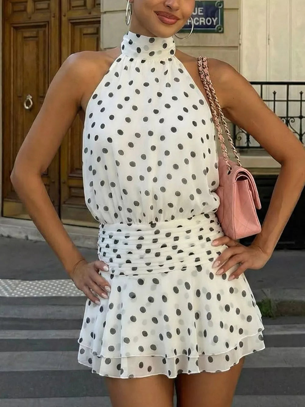 White polka dot halter neck mini dress with ruched waist and ruffled hem.