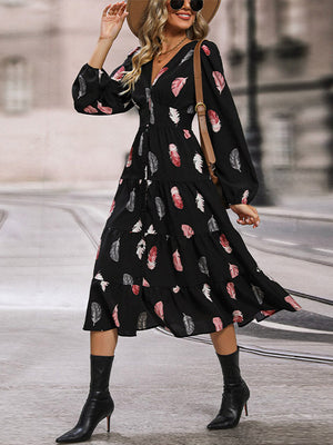 Black tiered midi dress with feather print, V-neck, and long sleeves.