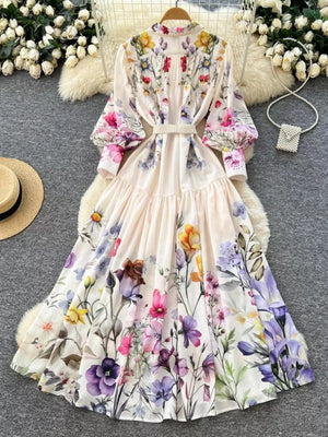 Vibrant floral midi dress with lantern sleeves, buttoned front, and tiered skirt.