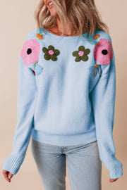 Light blue knit sweater with embroidered floral appliqué details and ribbed cuffs.