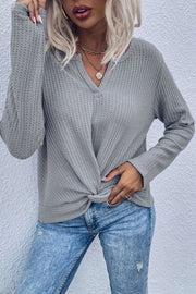 Gray waffle knit top with knot front detail and v-neck.